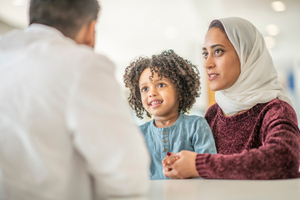 mother and child of middle eastern descent sitting with doctor