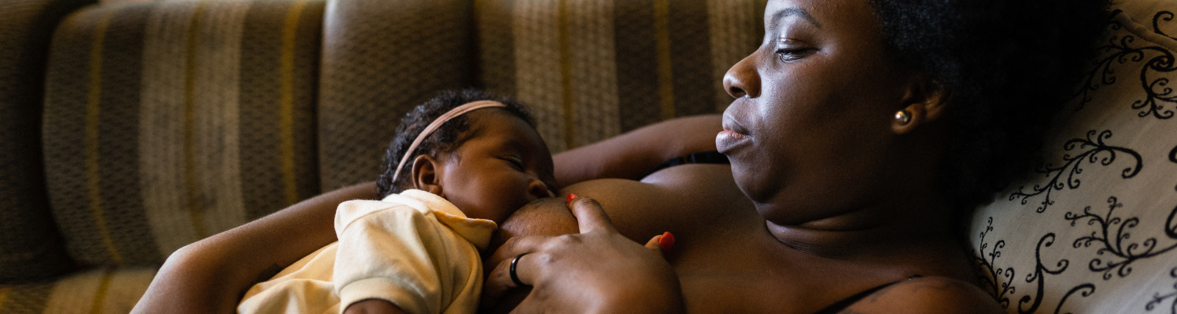 Black mother or parent breastfeeding newborn