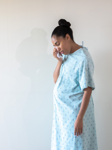 Black birthing person crying while pregnant 